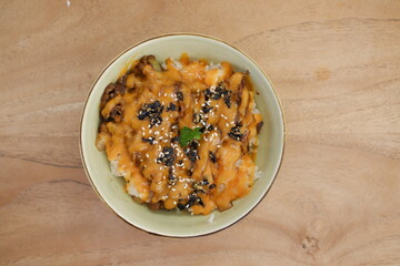 Rice topped with black sesame seeds and dried tomatoes in a bowl
