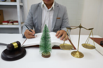 Lawyer siting at in Law office Justice law and wooden gavel tool on desk .concept