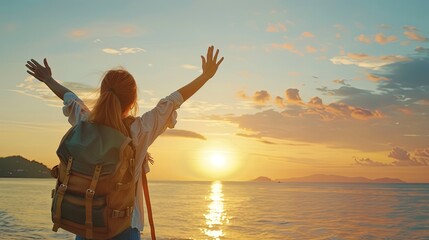 Confident woman with backpack with arms up relaxing at sunset seaside during a trip , traveler enjoying freedom in serene nature landscape