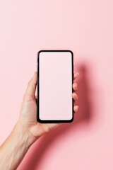 Hand Holding a Smartphone With a Blank Screen Against a Pastel Pink Background