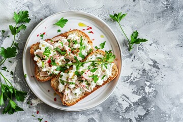 Delicious and nutritious toast with tuna ricotta and herbs on a white plate