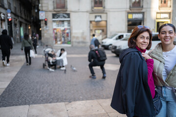 Madre e hija están sonriendo en una calle del Centro Histórico de Barcelona España.
