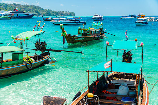 Traditional Thai boats dock and pass around Phi-phi Island. Traditional wooden boats are the preferred means of transportation for tourists when visiting Krabi, Thailand on March 23, 2024