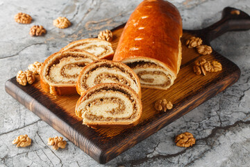 Eastern European Christmas and Easter nut roll made with ground walnuts closeup on the wooden board on the table. Horizontal