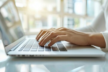 Hands typing on a laptop keyboard, researching for an online course project