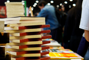 Some books stacked on a table on display, at a book fair