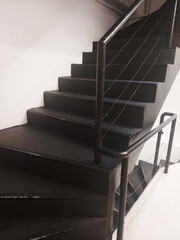 Black stairs for going up and down in a building.