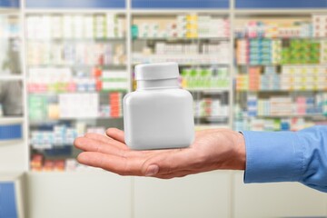Plastic bottle in hand. Packaging of vitamins or supplement