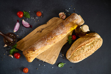 freshly baked bread on wooden cutting board on dark table