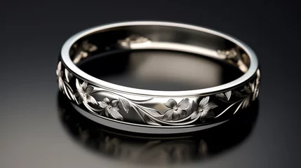 Poster Luxurious display of a polished silver bangle with elegant lily engravings, arranged on a glossy black surface for a striking contrast © kitidach