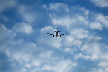Commercial jet flying on white clouds background. back, rear view of plane, Airplane fly on blue sky backdrop. take off.