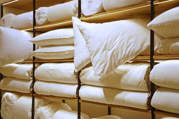 Pillows and blankets are stacked in a rack.