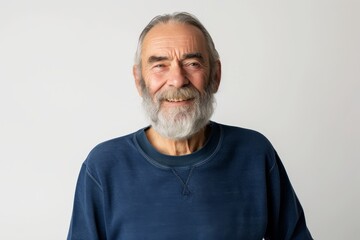 Obraz premium Smiling old man with beard and gray hair in blue sweatshirt stands alone looks at camera headshot