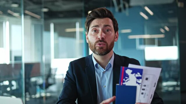 Confident travel agent talking to camera and showing blue passport with documents on empty office background. Experienced worker explaining rules and hacks for facilitating immigration opportunities.