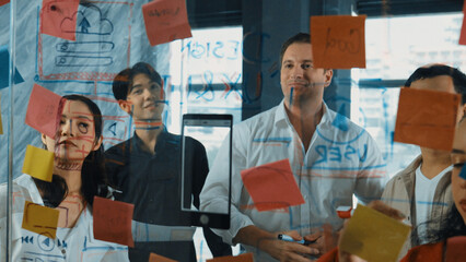 Portrait of professional business team brainstorming marketing idea by using sticky notes to share...