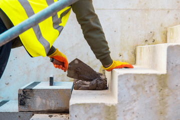 Concrete steps under construction as a team of builders install heavy concrete blocks
