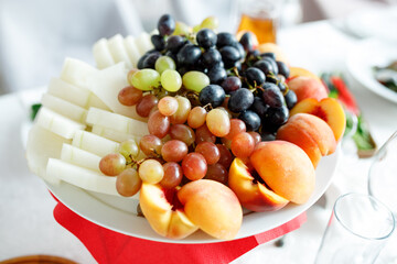 Peaches grapes and melon on a white plate