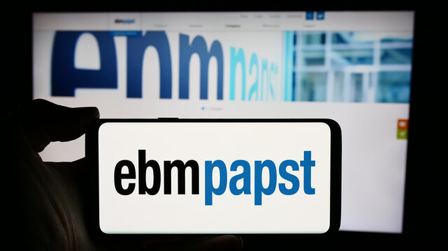 Stuttgart, Germany - 04-13-2024: Person holding cellphone with logo of German electric motor company EBM-Papst Gruppe in front of business webpage. Focus on phone display.