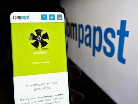 Stuttgart, Germany - 04-13-2024: Person holding mobile phone with web page of German electric motor company EBM-Papst Gruppe in front of logo. Focus on center of phone display.