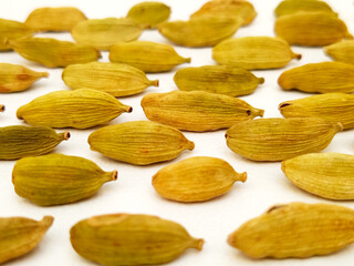 Green cardamom macro closeup on white background, horizontal, texture of cardamom seeds, spice or...