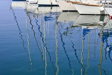 Reflection of sailboats on the water surface in the port of Bastia, Corsica, in a sunny afternoon