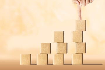 Business person stack wooden cubes on table