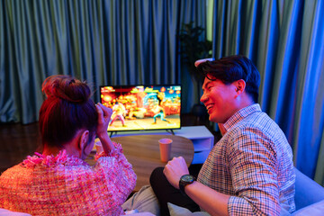 Couple gamer with joysticks playing fighting video game on tv screen, man getting win challenge...
