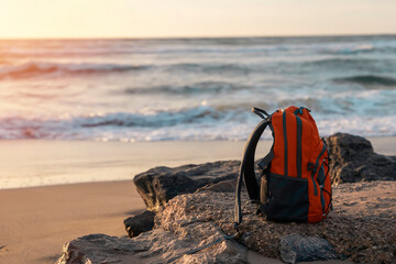 Orange backpack on the seaside against the sea in fantastic weather. Travel insurance concept....