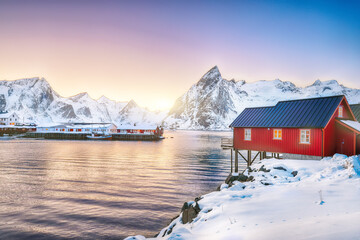 Traditional Norwegian red wooden houses (rorbuer) on the shore of  Reinefjorden near Hamnoy village...