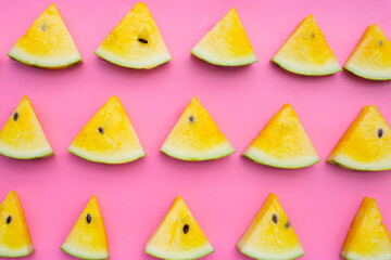 Yellow watermelon slices on pink background.