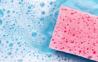 Cleaning sponge in foam of dishwashing liquid. Washing dishes concept