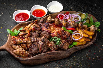 Meat set for a large group. A dish of different types of meat: beef steak, pork cuts and ribs,...