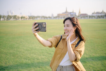 Traveler asian woman in her 30s making a livestream or selfie on smartphone while explores its sacred beauty. Uncover the religious significance and cultural richness of this iconic landmark. - 792476902