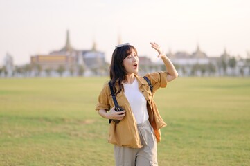 A Traveler Asian woman in her 30s exploring Wat Pra Kaew. From stunning architecture to friendly locals, she cherishes every moment, capturing it all in her heart and camera for years to come. - 792477994