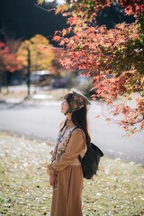 Kyoto's fall beauty, Asian woman in a casual dress enjoys a holiday, capturing the vibrant foliage, cheerful smiles, and the beauty of Kyoto's scenic destinations. - 792478505