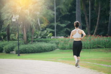 asian woman jogger running in green nature public park. - 792478748