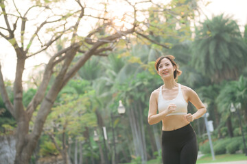 asian woman jogger running in green nature public park. - 792478751