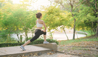 Female jogger. Fit young Asian woman with sportswear stretching muscle in park before running and enjoying healthy outdoor. Fitness runner girl in public park. Wellness being concept