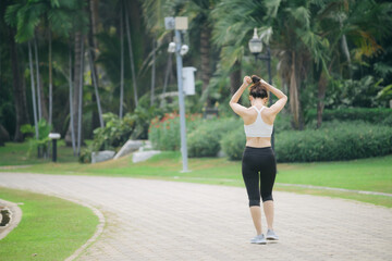 asian woman jogger running in green nature public park. - 792478759
