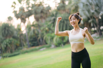 Happy fitness woman achieve goal, finish marathon with hands up, celebrating victory while jogging, triumphing in park - 792478906