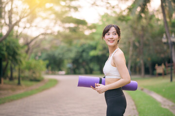 pretty fitness yoga woman in the park with yoga mat - 792478954