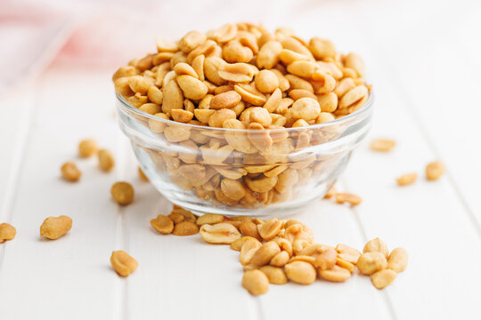 Salted roasted peanuts in bowl on kitchen table