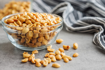 Salted roasted peanuts in bowl on kitchen table - 792479514
