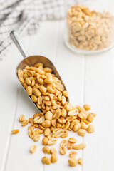 Salted roasted peanuts in scoop on kitchen table
