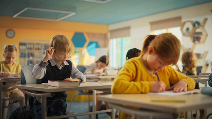 Primary School Children Working on a Test Assignment in Class: Smart Diverse Kids Focused on...