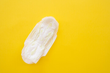 Women's sanitary napkin on a yellow background close-up.