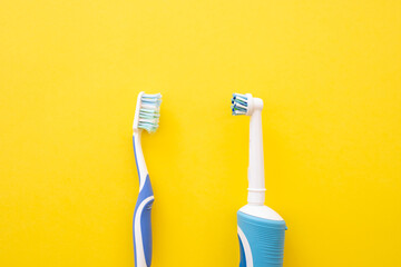 Electric toothbrush on a yellow background. Old and new dental account