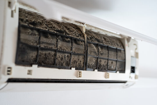 Dirty in dust and mold air conditioner filter close-up. Home air conditioner maintenance