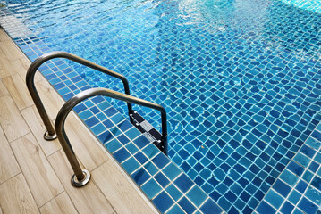Stainless steel swimming pool ladder. - obrazy, fototapety, plakaty