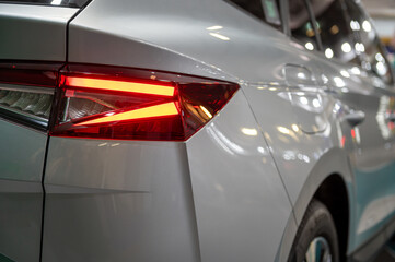 A close-up of a car tail light on a vehicle. - obrazy, fototapety, plakaty